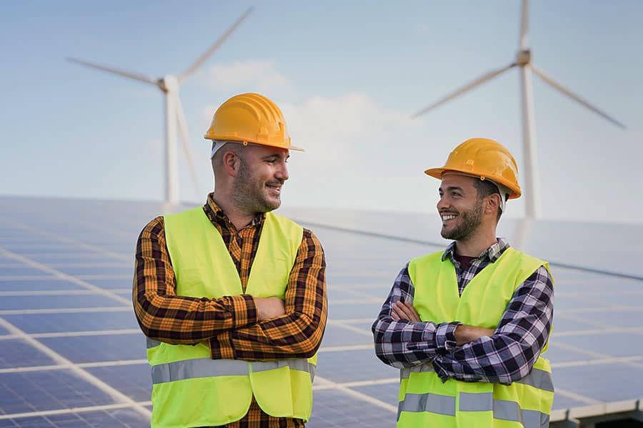 E2SOL Employees smiling at each other with solar panels in background